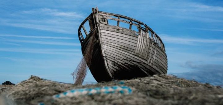 old boat with finish net on the shore