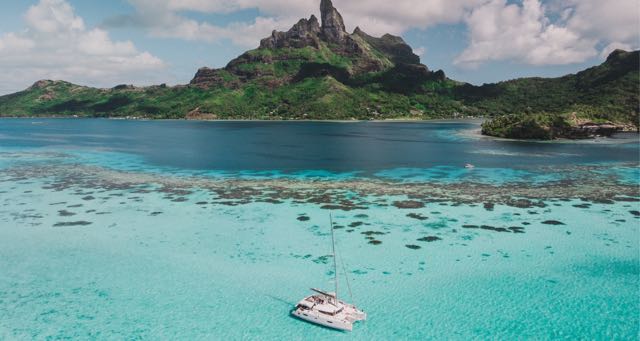 boat anchored by a shallow coral reef