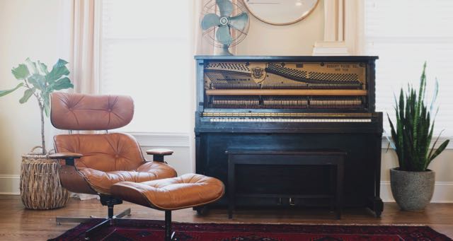 old piano with a reading chair with ottoman