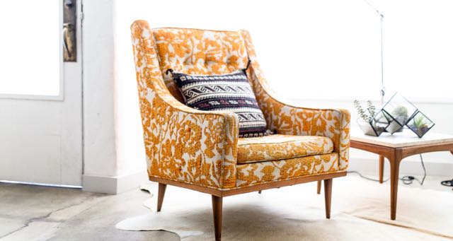 a yellow reading armchair in a brightly lit living room