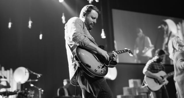 man playing guitar on stage