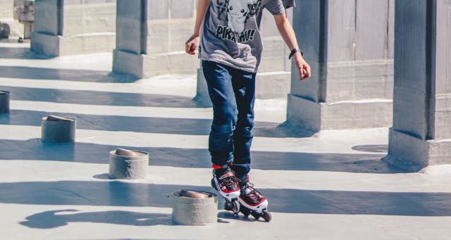 a boy roller blading between columns