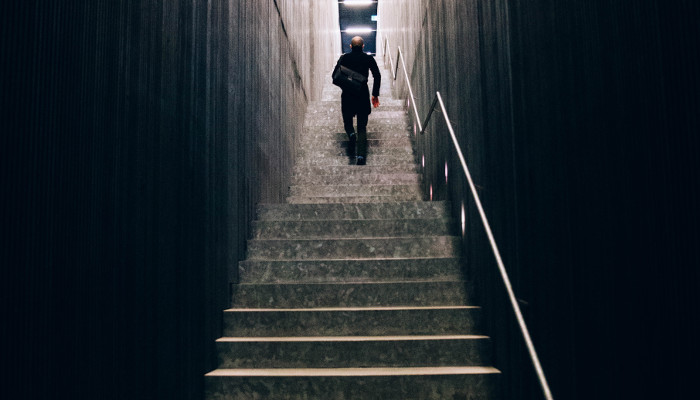 man with bag climbing stairs