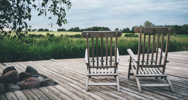 deck with chairs overlooking a green field