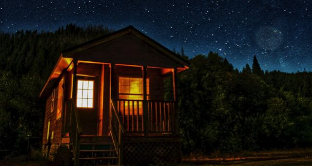 cottage in the forest with starry night sky